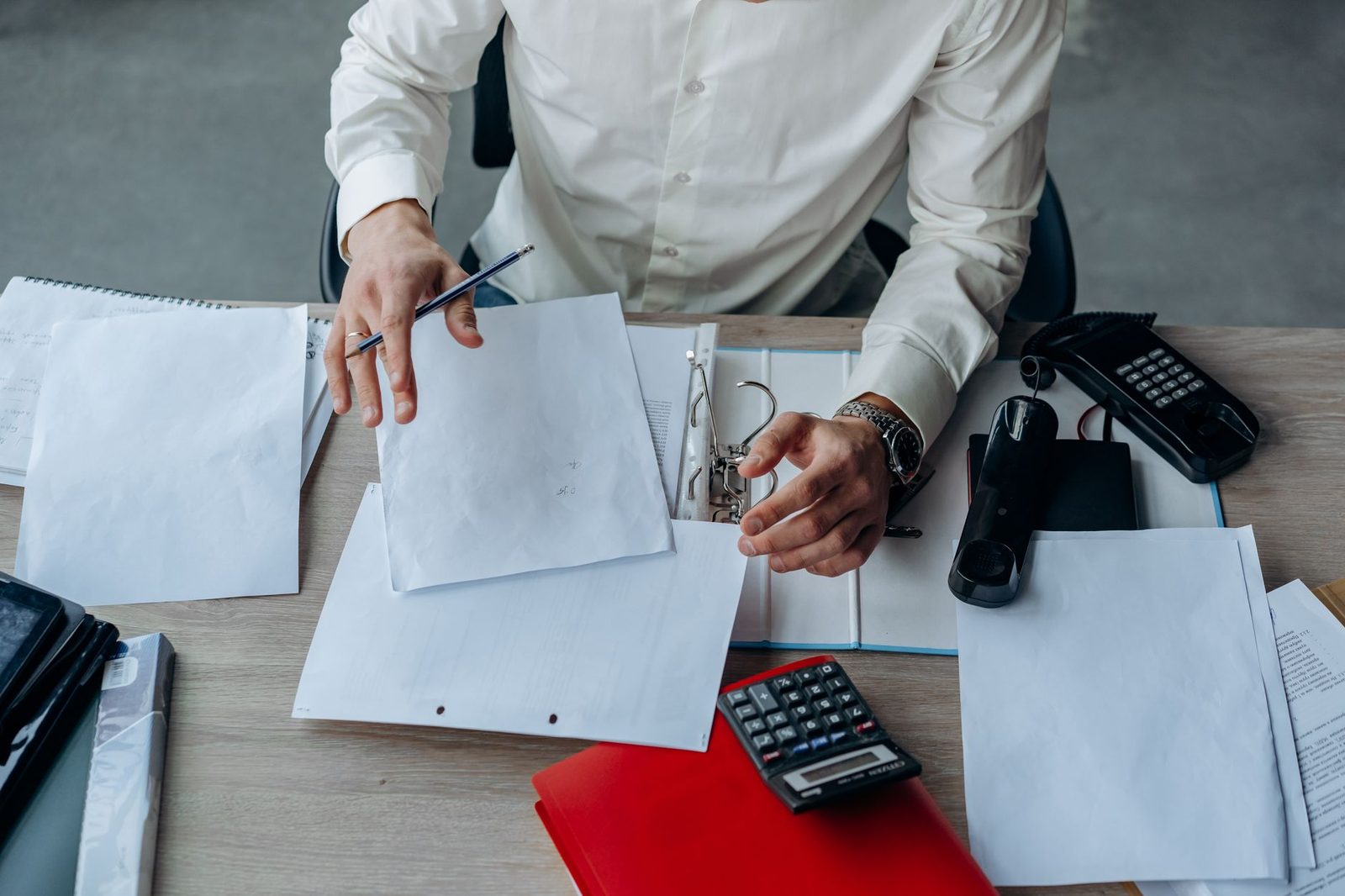Professional organizing documents at a desk during digitization