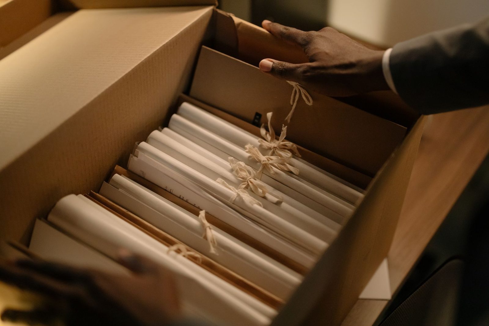 Hands sorting files in an archive box